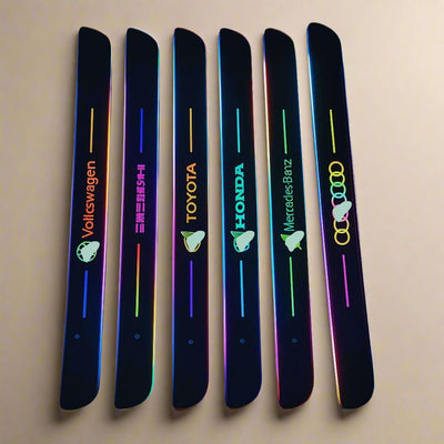Set of illuminated car door sill lights with brand logos including Volkswagen, Toyota, Honda, Mercedes-Benz, and Audi