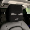 Black knitted car headrest cover with eye-shaped cutout design, installed on a car seat in the interior