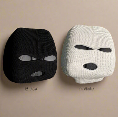 Set of black and white knitted car pillow covers with eye-shaped design, displayed on a beige background