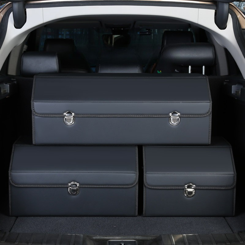 Set of three dark blue leather car trunk storage boxes placed inside a vehicle’s open trunk