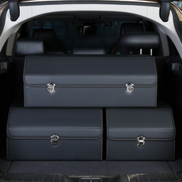 Set of three dark blue leather car trunk storage boxes placed inside a vehicle’s open trunk